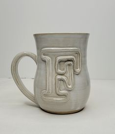 a ceramic mug with the letter f on it