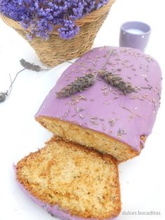 a loaf of lavender cake next to a wicker basket with lavender sprinkled on it