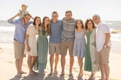 a group of people standing next to each other on a beach