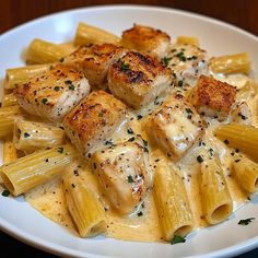 pasta with chicken and sauce on a white plate