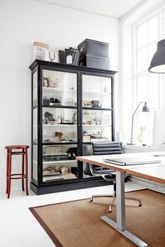 an office area with a desk, chair and bookcase in the middle of it