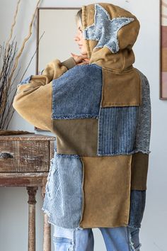 a person wearing a jacket made out of old jeans and denims, standing in front of a mirror