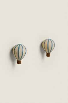 two blue and white striped hot air balloons on a white wall, one is in the shape of a balloon