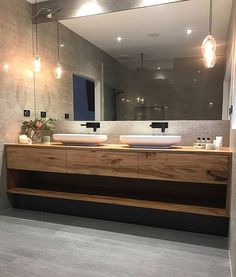 a bathroom with two sinks and a large mirror on the wall above it's counter