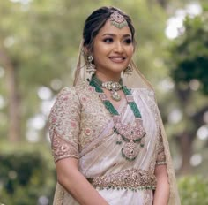 a woman in a bridal outfit posing for the camera with her hands on her hips