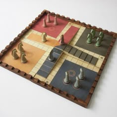 a wooden board game set up on a white surface with chess pieces in the middle