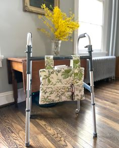 an elderly woman's walker with a bag on it and flowers in the background