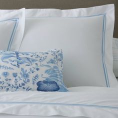 a bed with blue and white pillows on top of it