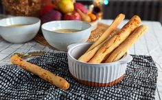 some bread sticks are in a bowl on a table