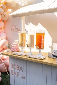 an outdoor bar is decorated with balloons and candles for the guests to drink from it