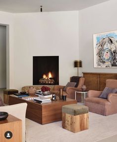 a living room filled with furniture and a fire place in the middle of the room