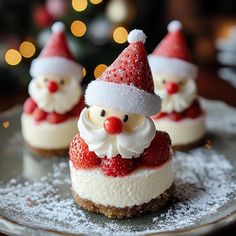 santa clause cheesecakes with strawberries on a silver plate in front of a christmas tree