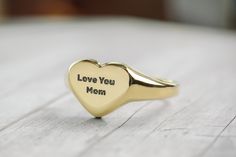 Our Custom "Love You Mom" Heart-Shaped Gold Signet Ring is a loving tribute to the special woman in your life. This ring combines the timeless elegance of a heart-shaped gold signet with the personal touch of a "Love You Mom" engraving. It's an exquisite piece of jewelry that's perfect for expressing your deep affection and appreciation for your mom. Whether it's Mother's Day, her birthday, or any day you want to celebrate her, this ring is a beautiful way to say "I love you." Crafted with care Dna Jewelry, Mothers Day Rings, Heart Shaped Ring, Mom Ring, Ring Heart, Signet Rings, Fancy Gifts, Gold Signet Ring, Heart Shaped Rings