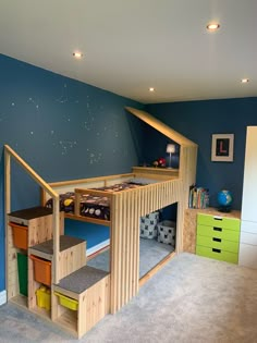 a child's bedroom with blue walls and carpeted flooring, built in bunk beds