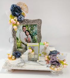 a wedding photo frame with flowers and an umbrella on the side, next to it