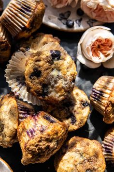 blueberry muffins are piled on top of each other next to some flowers