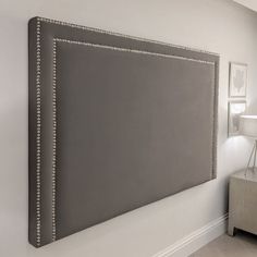 a large gray wall hanging over a bed in a bedroom