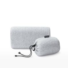 two grey bags sitting next to each other on a white surface with one bag in the middle