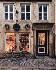 an old building with a bicycle parked in front of it and the words anthropologie written on the window