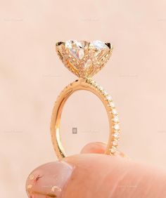 a hand holding a diamond ring in front of the camera