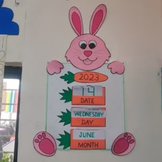 a pink bunny holding a carrot next to a sign that says date wednesbury day