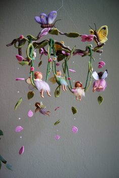 a mobile with flowers hanging from it's sides and butterflies on the strings above