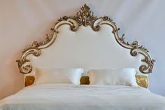 a white bed with gold headboard and pillows