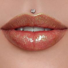 a woman's lips with gold glitters on them and a diamond in the middle