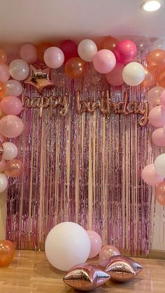 balloons and streamers are on the floor in front of a backdrop that says happy birthday