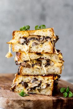 three pieces of bread stacked on top of each other with mushrooms and cheese in them