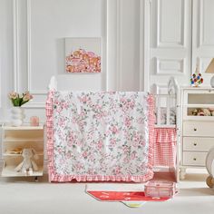 there is a baby crib with pink and white flowers in the beddings