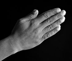 black and white photo of two hands holding each other in the air with their palms together