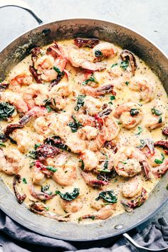 a skillet filled with shrimp and spinach