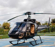 a black helicopter is parked on the tarmac