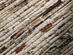 the texture of an area rug with brown and white stripes is shown in close up