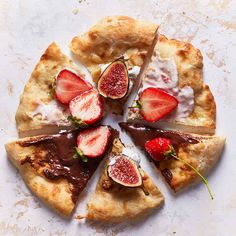 a sliced pizza with chocolate sauce, strawberries and whipped cream