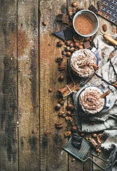 an overhead view of two desserts on a table with nuts, chocolate and cinnamon