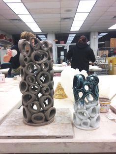 two vases sitting on top of a table in a room filled with other items