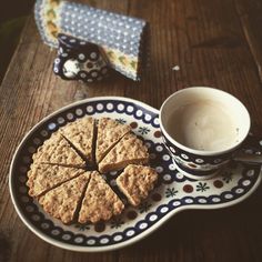 a plate with some cookies on it next to a cup of coffee