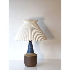 a blue and white lamp sitting on top of a table next to a white wall