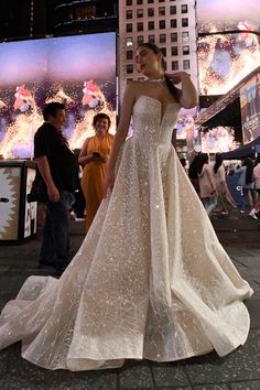 a woman in a white dress standing on the street