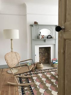 a rocking chair sitting in front of a fire place