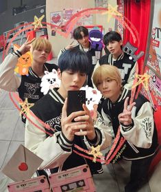 group of young men standing in front of a mirror taking a selfie with their cell phones