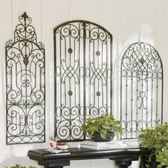 a table with two potted plants on top of it next to an iron screen