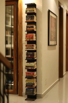 a tall stack of books sitting on top of a white floor next to a doorway