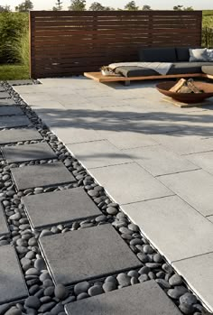 an outdoor seating area with large rocks on the ground