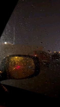 rain drops on the windshield of a car at night