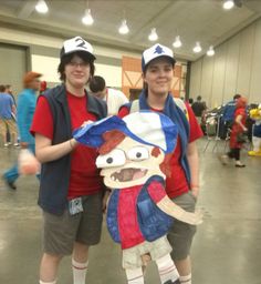 two people standing next to each other in front of a crowd wearing baseball caps and costumes