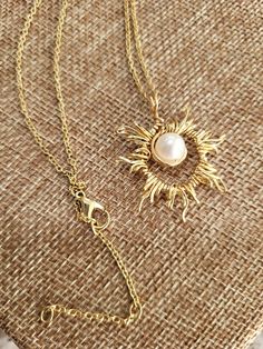 Pendentif perle Solara Rehaussez votre style avec le magnifique pendentif perle Solara, un mélange radieux d'élégance et de savoir-faire. Cette superbe pièce est méticuleusement fabriquée à la main avec un motif en fil de fer sunburst, berçant une perle véritable de haute qualité en son centre. Suspendu à une délicate chaîne dorée, ce pendentif respire le charme intemporel et la sophistication. Que vous recherchiez un cadeau attentionné ou un accessoire unique pour vous-même, le pendentif perle Solara est parfait pour : * Célébrer des occasions spéciales comme des anniversaires, des anniversaires ou Noël * Honorer des jalons tels que des remises de diplômes ou des promotions * Ajoutez une touche de beauté céleste à vos tenues de tous les jours Chaque pendentif est fabriqué avec soin, ce qu Golden Chain, Accessories Unique, Chain Pendants, Pearl Pendant, Chain Lengths, Thoughtful Gifts, Jewelry Necklace Pendant, Pendant Necklaces, Jewelry Necklaces