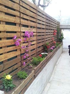 a wooden fence with flowers growing on it